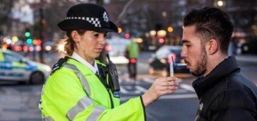 POlice officer giving a man a drug test by the roadside