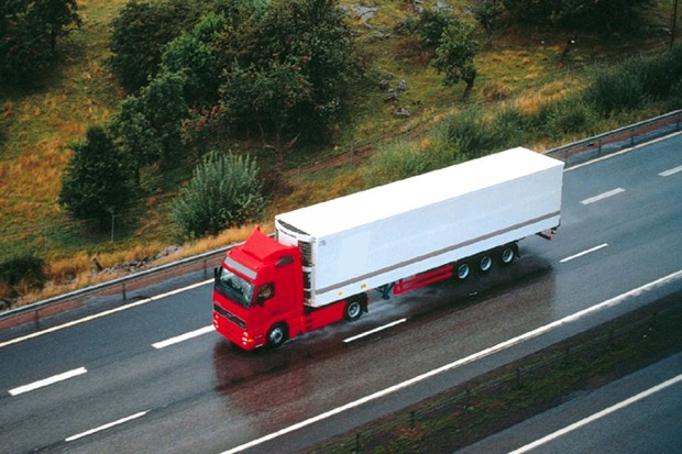 A red lorry driving on the motorway