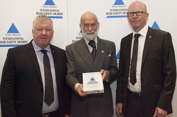 Prince Michael holding a Road Safety Award with DVSA's Ronald Arnott and Mark Horton