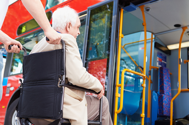 Man in wheelchair about to get on to a bus