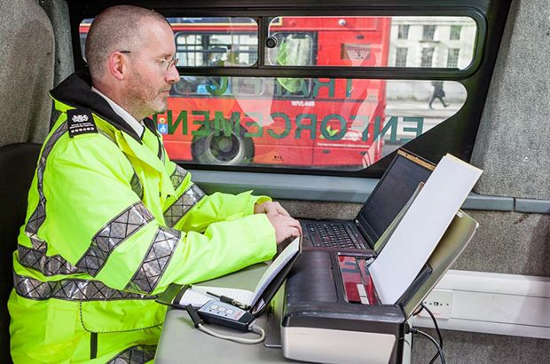 A DVSA traffic examiner at a computer checking vehicle records