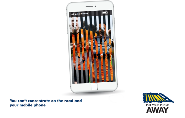 A mobile phone with two competing images - one of a football game and another of traffic.