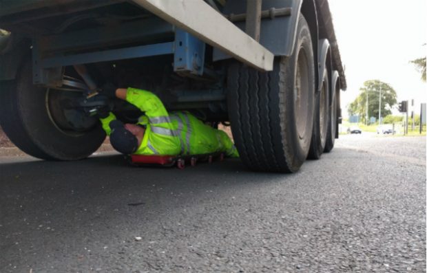 DVSAn enforcement officer checking under a lorry