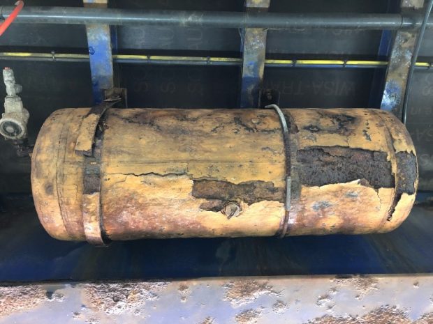 Picture of severely corroded air brake tank only being held on by one strap