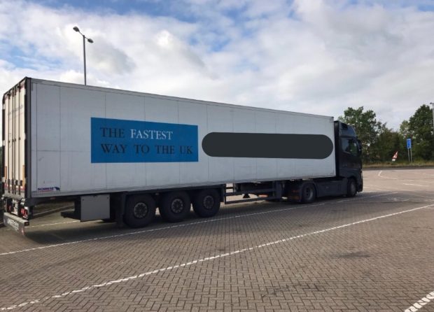a lorry parked at a DVSA enforcement site with a sign outlining 'The fastest way to the UK' on its side