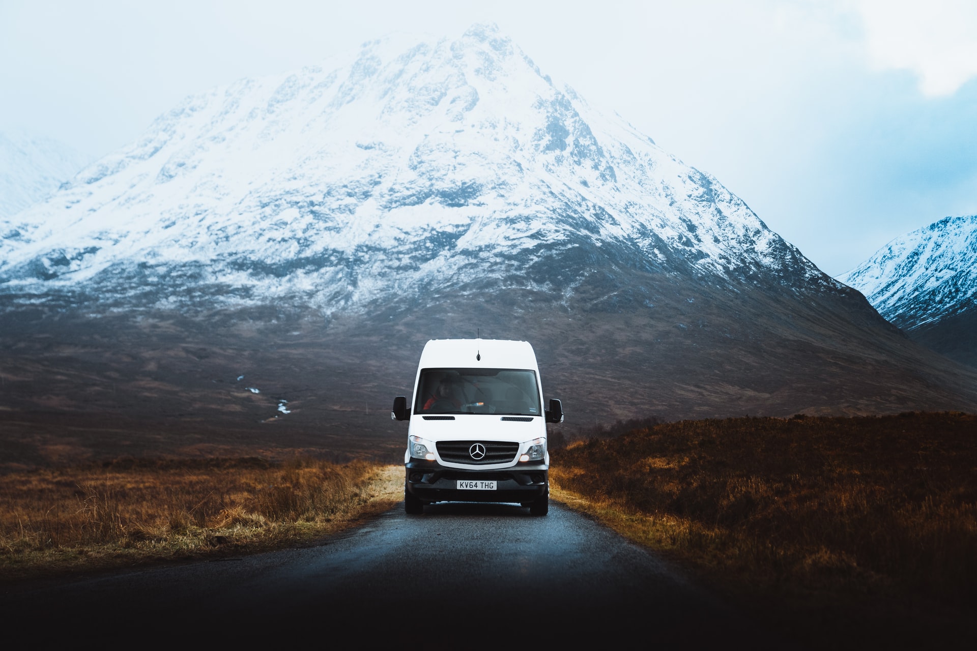 A white van against a mountain.